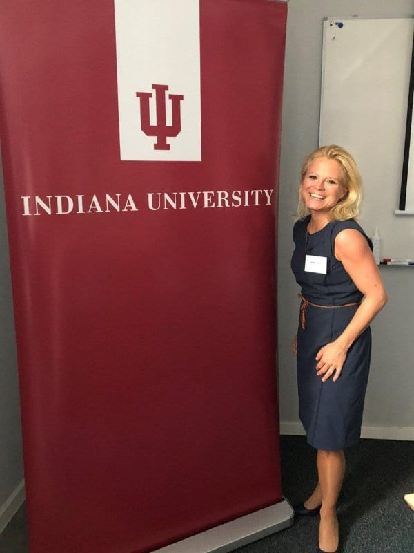 The Indiana University (IU) alum poses next to an IU flag