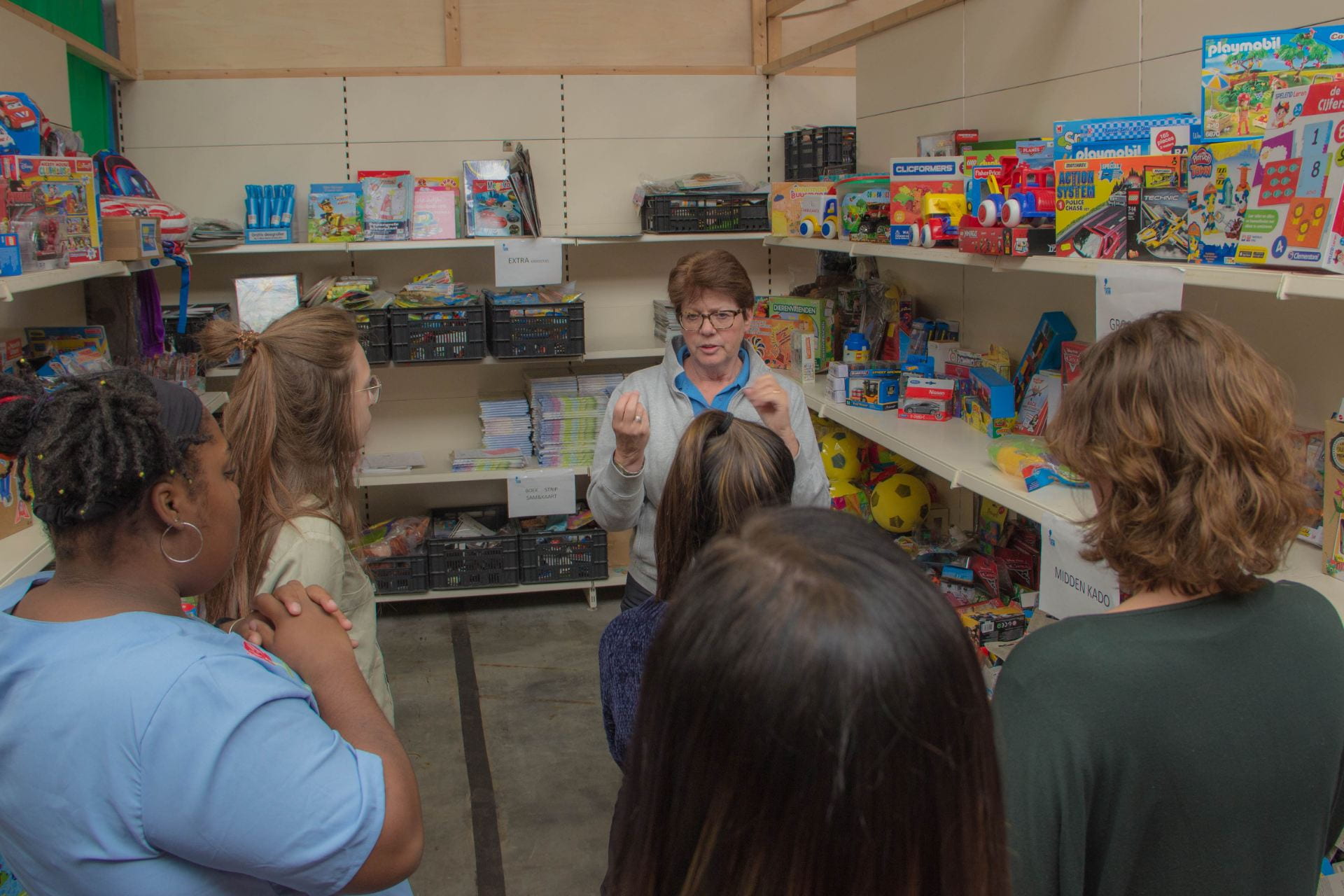 A volunteer at Jarige Job discusses how to pack a birthday box for a local child. 