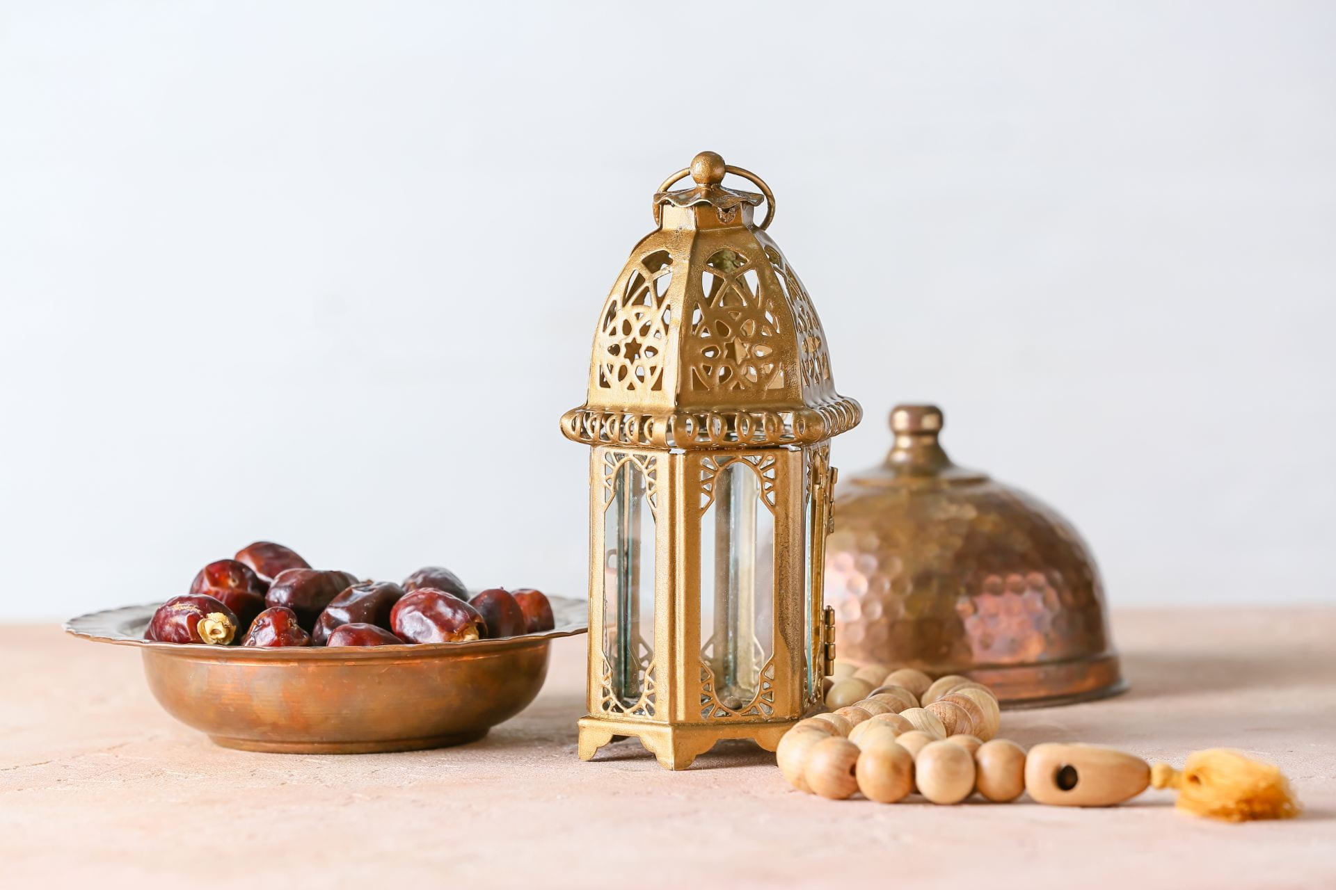 Arabic lamp and tasbih with dates on light background