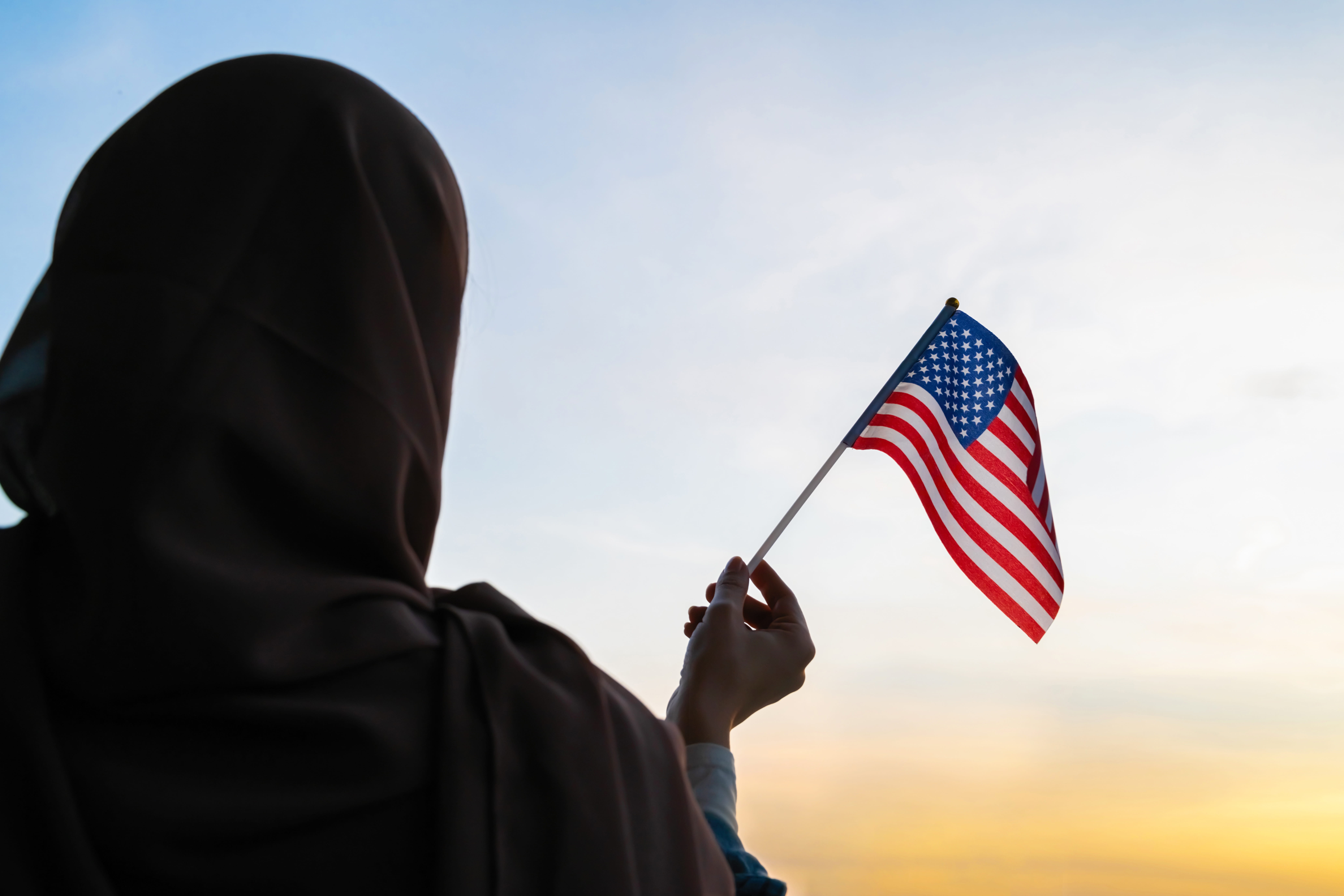 Silhouette of Muslim person in scarf with American.